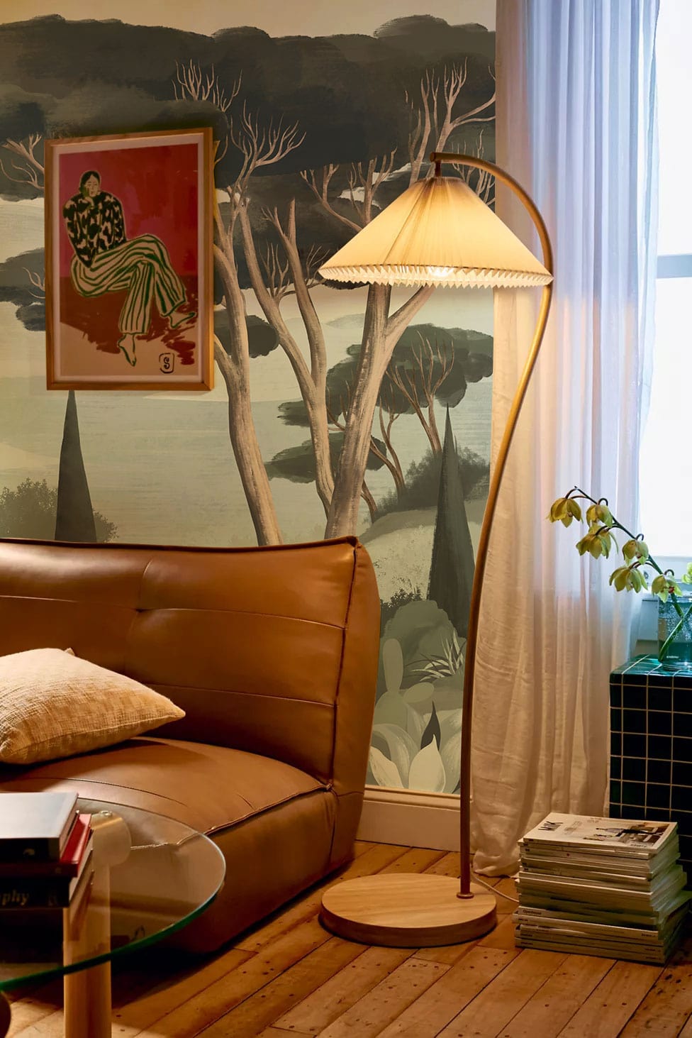 Tranquil Evergreen mural in room with brown leather sofa, wooden flooring, and vintage floor lamp.