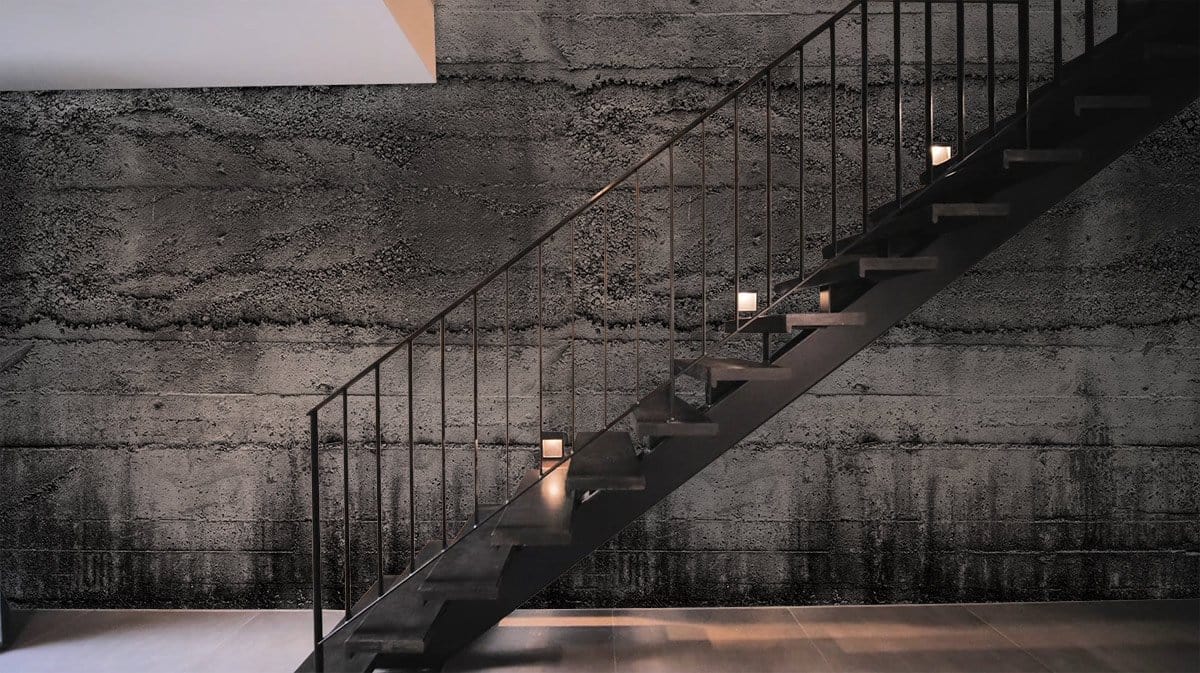 Industrial grey concrete textured mural wallpaper, modern interiors, metal staircase, wooden flooring. Urban style.