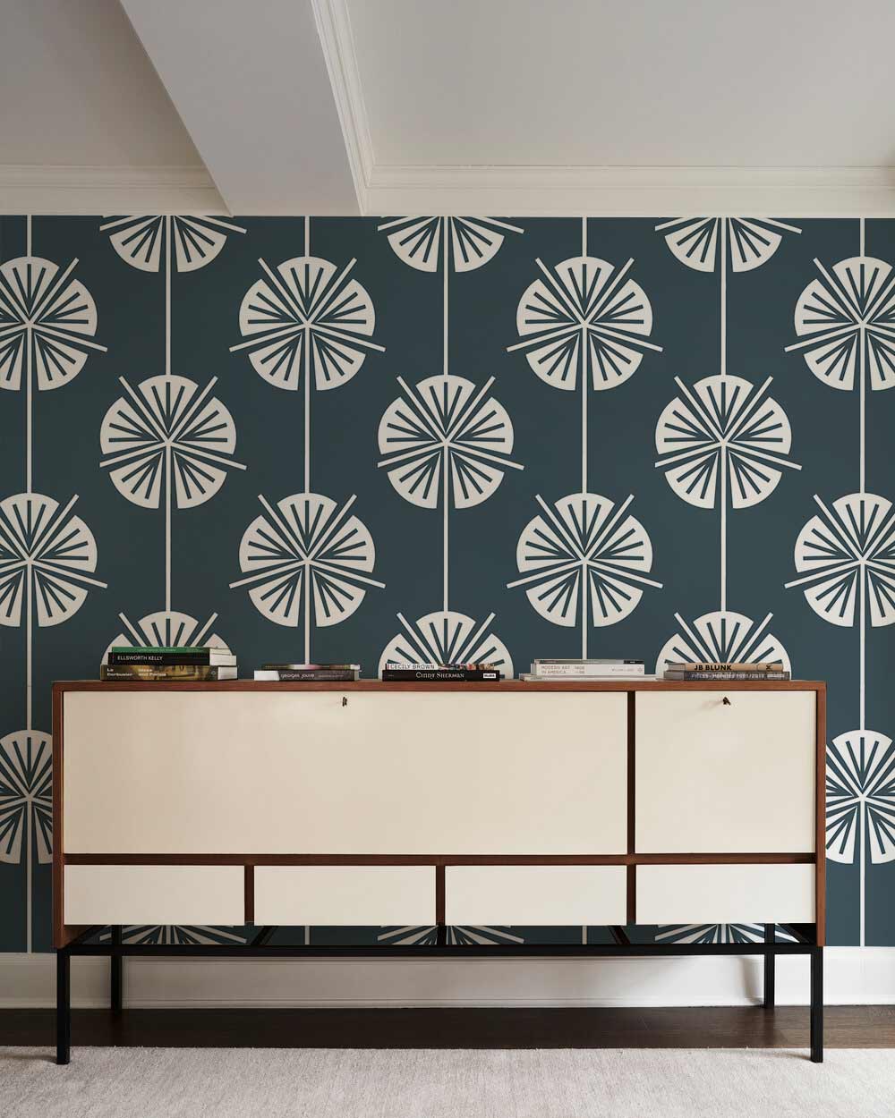 Modern charcoal floral wallpaper with stylish grey tones, mid-century console, white trim, light flooring.