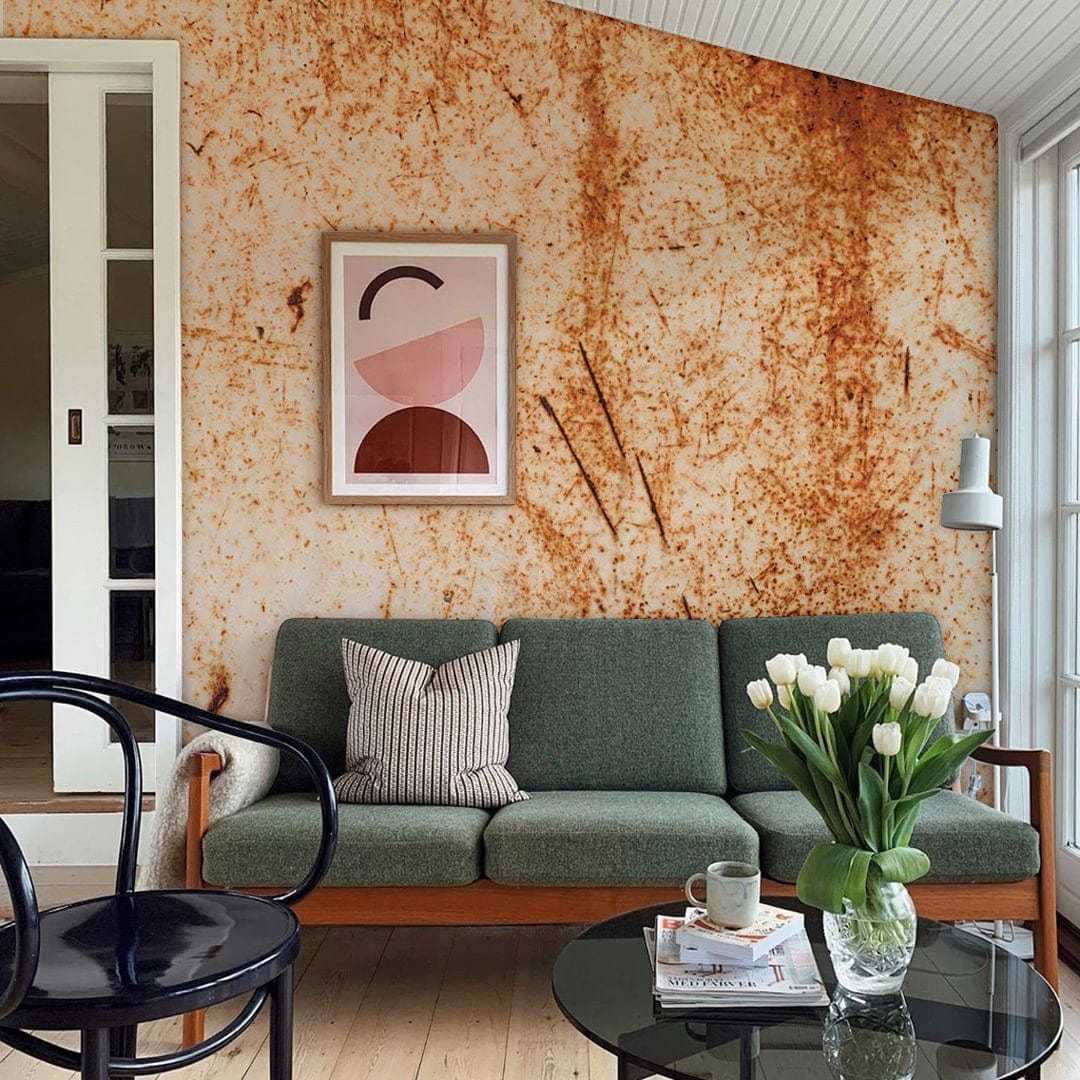 Vintage Rust Texture Mural Wallpaper, industrial aesthetic, green sofa, black chair, light wooden flooring.