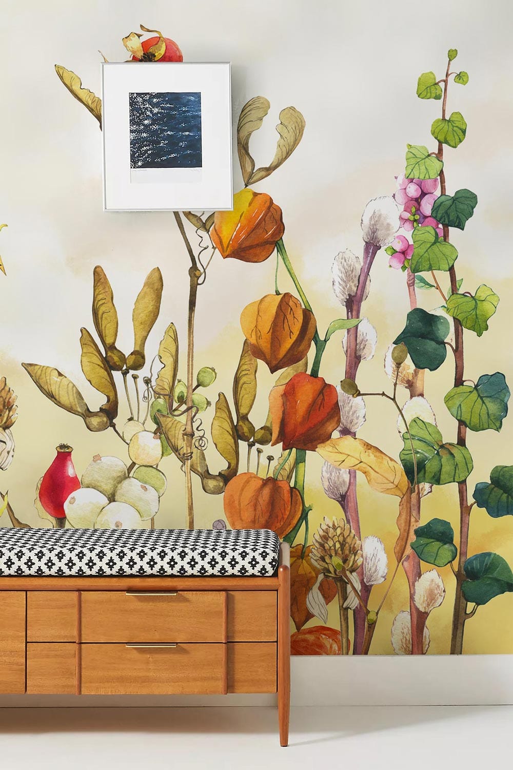 Vintage floral mural wallpaper with autumnal hues, mid-century wooden bench, modern art, white wall.