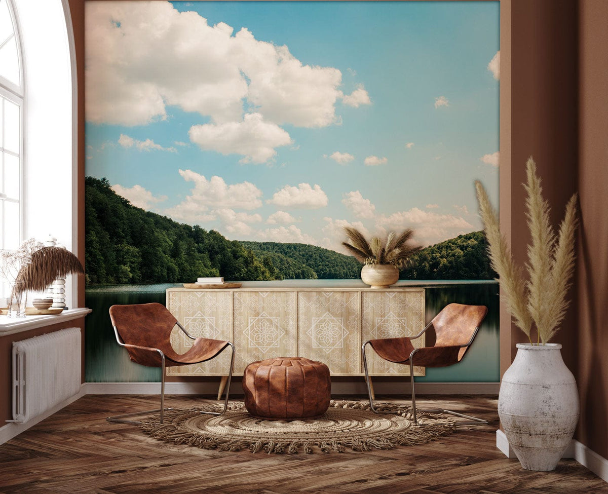 Scenic lake mural wallpaper in rustic living room with brown chairs, modern sideboard, wood flooring.