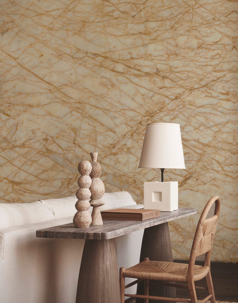Elegant beige marble textured wallpaper with natural stone, cream sofa, wooden table, and woven chair.