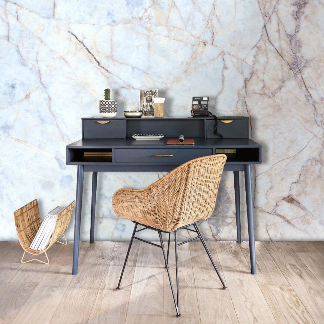 Cream beige marble wallpaper in modern office with wicker chair, wooden flooring, and dark desk.