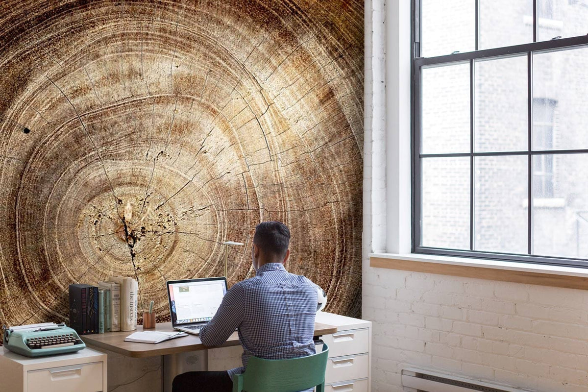 Natural woodgrain tree rings wallpaper in office with white brick wall, desk, and vintage typewriter.