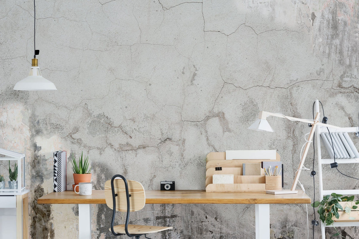 Alt text: Industrial concrete effect wallpaper, wooden desk, black chair, pendant lamp in minimalist study.