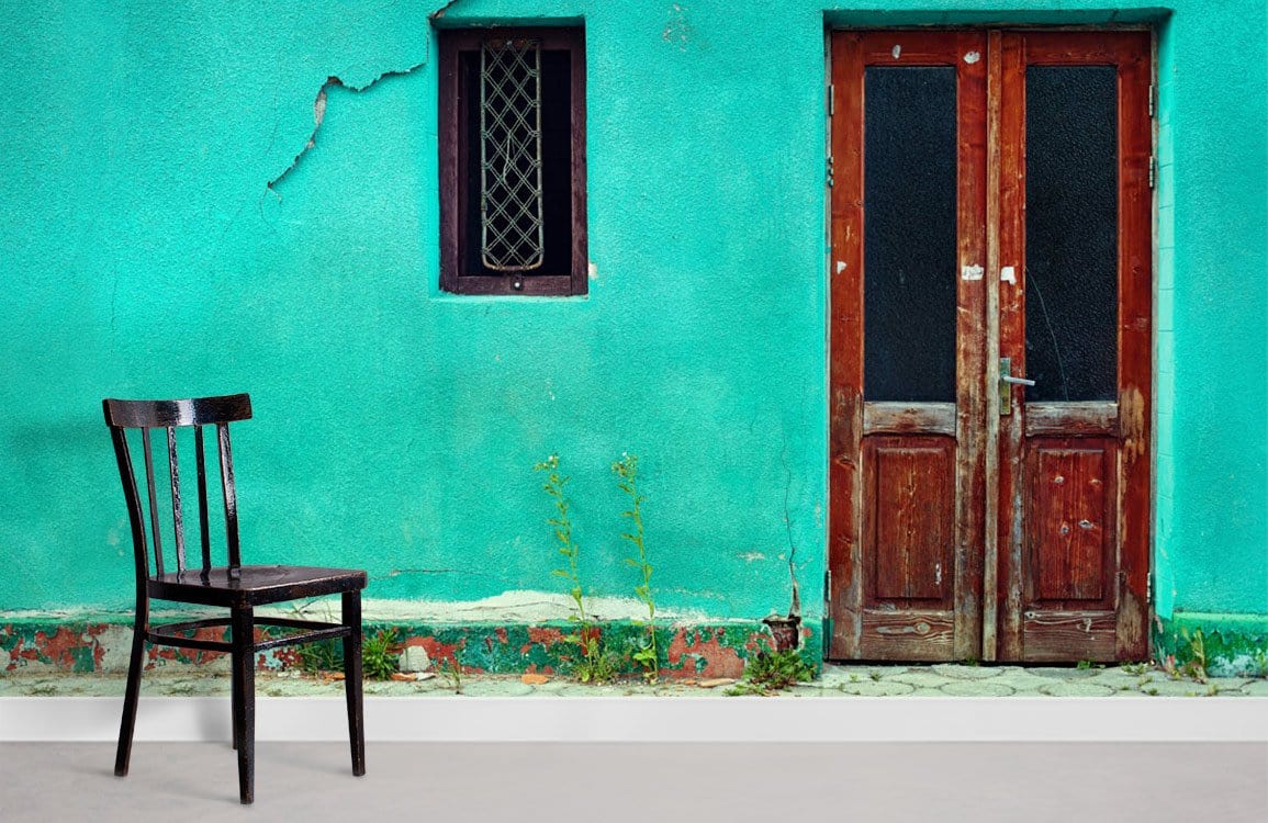 Vintage Teal Wall Mural with Rustic Wood Door, black chair, minimalist design, grey flooring.