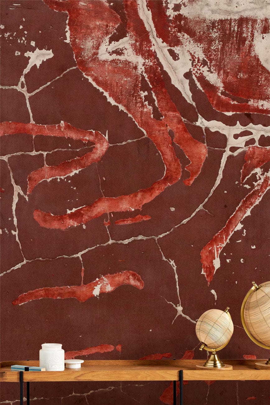 Rustic red cracked earth mural wallpaper with wooden table, globes, and modern interior style.