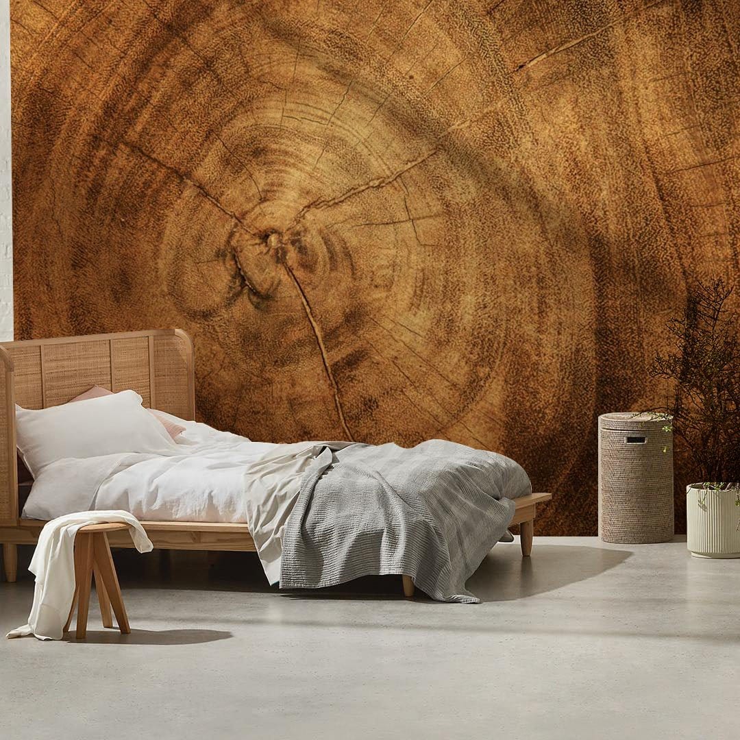 Rustic wood grain effect wallpaper in bedroom with light wood bed, neutral bedding, concrete flooring.