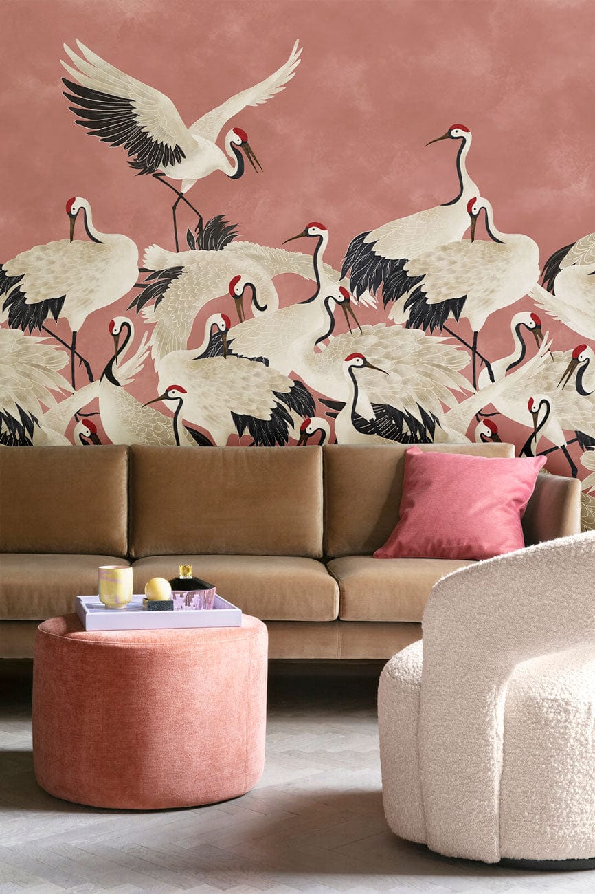 Elegant Coral Crane Pattern Wallpaper in modern lounge with tan sofa, pink ottoman, and textured chair.
