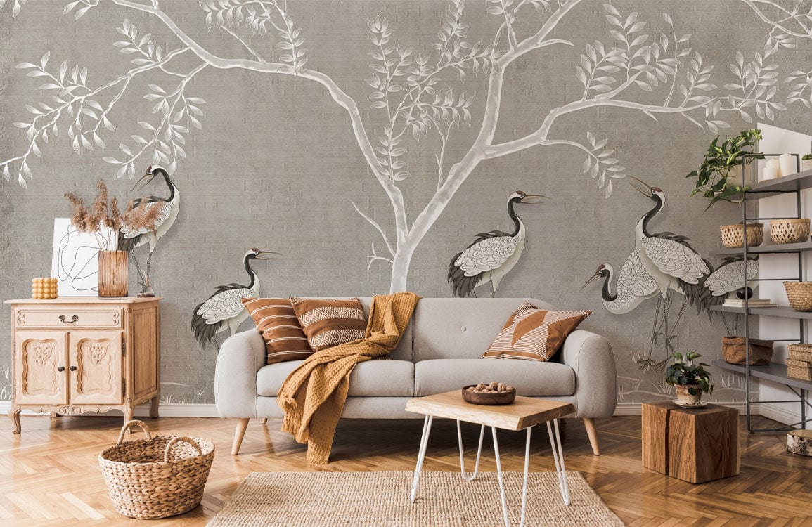 Elegant grey crane wallpaper in cosy living room with grey sofa, wooden floor, rustic cabinet.