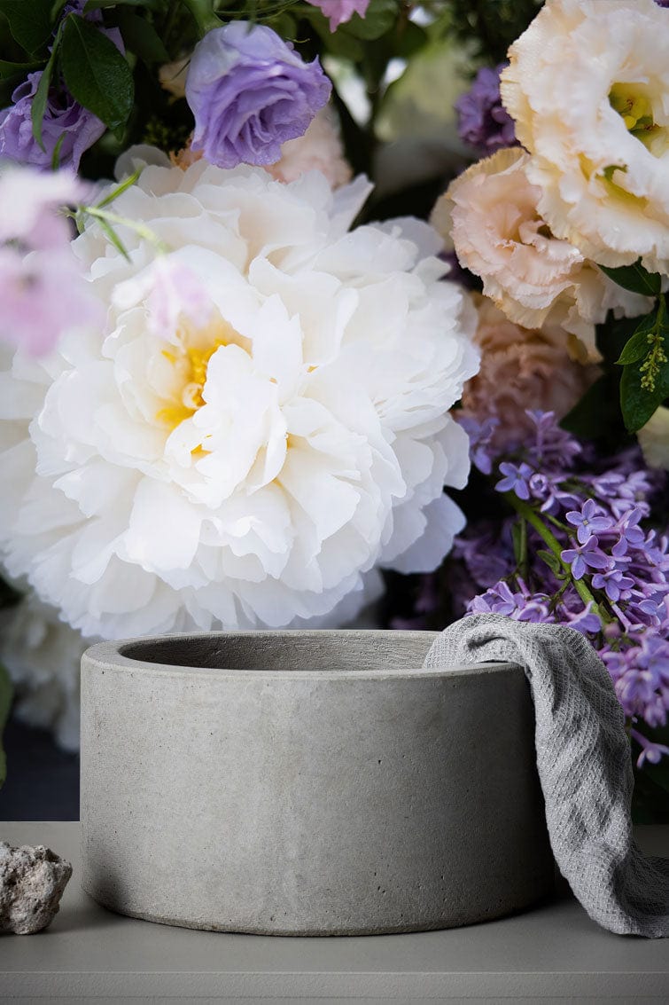 Elegant Floral Blossom Wallpaper with white, purple, and green botanical design, featuring a concrete planter.