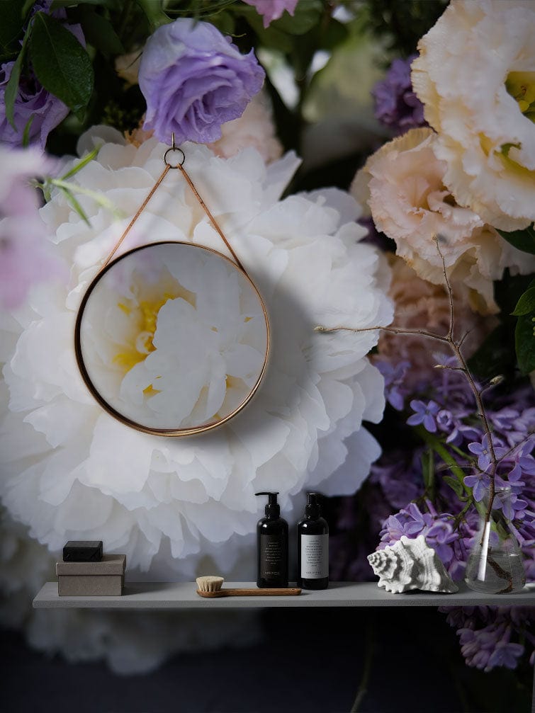 Elegant floral wallpaper with white, purple blooms; includes hanging mirror and shelf with decor items.