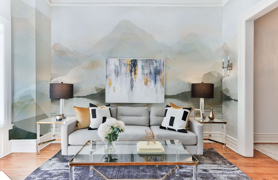 Tranquil watercolour mountain mural wallpaper; neutral tones; grey sofa; glass coffee table; modern living room.