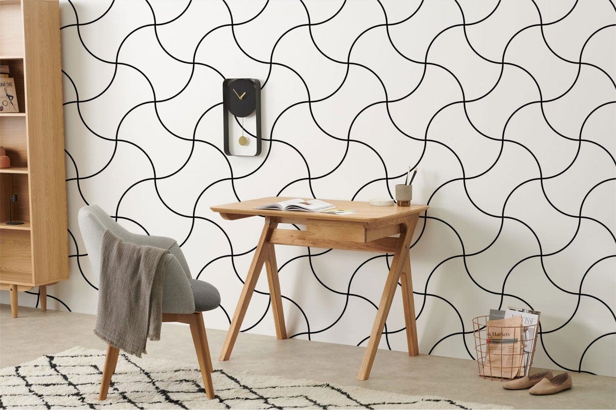 Monochrome Curved Line Wallpaper in stylish interior; grey chair, wooden desk, beige floor, geometric rug.