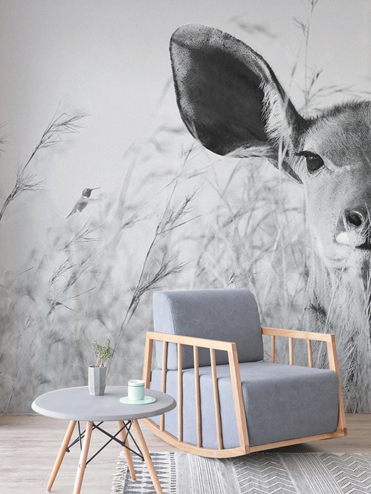 Monochrome Safari Serenity mural with grey armchair, light wood flooring, round table in modern living room.