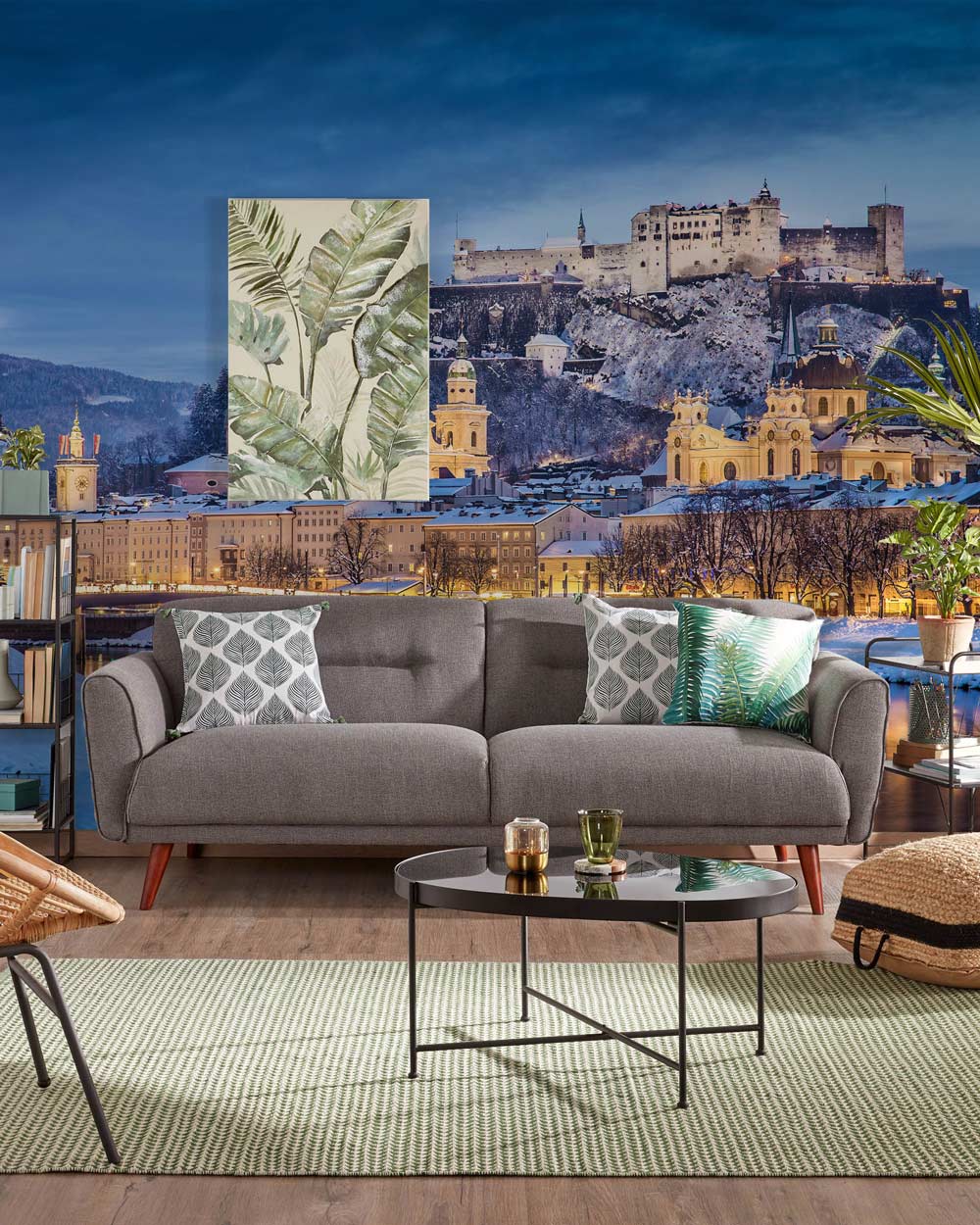 Enchanting Winter Castle mural wallpaper in blue hues, grey sofa, round black table, green rug.