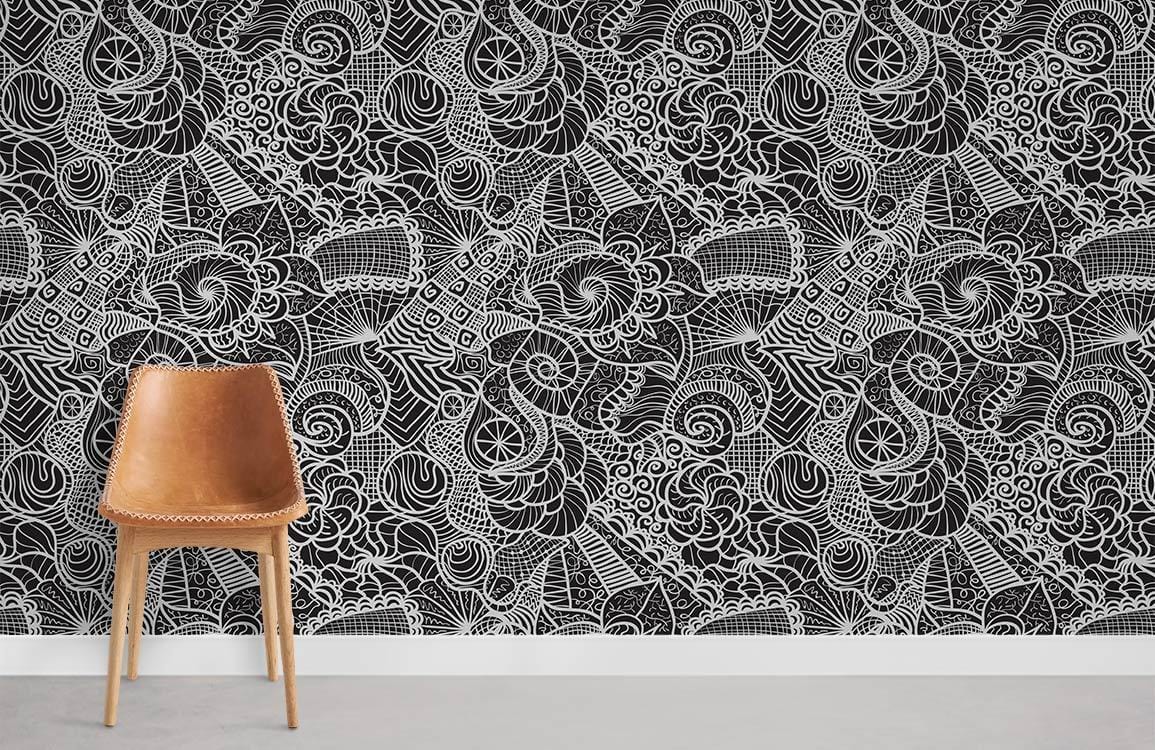 Intricate black and white abstract patterned wallpaper with brown leather chair and grey floor in lounge.