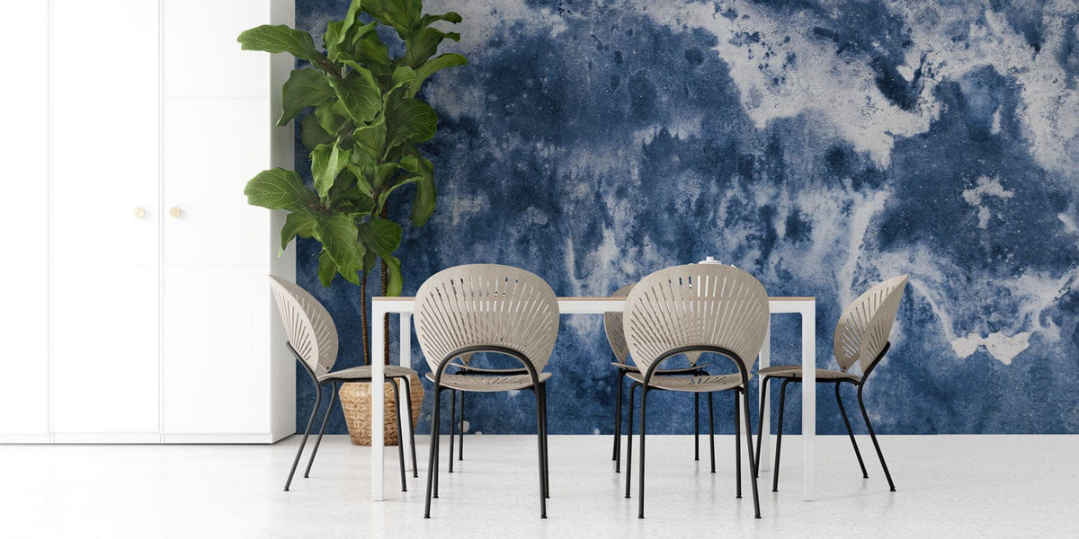 Dining room with Indigo Watercolour Abstract Mural Wallpaper, modern chairs, white table, plant, minimalist style.