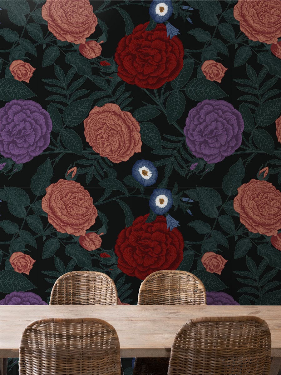 Vintage floral wallpaper with rich red, pink, and purple blooms behind wicker dining chairs.