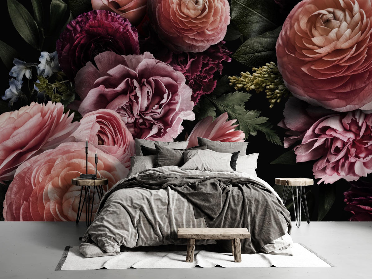Luxury dark floral wallpaper with pink and purple blooms behind grey bed and rustic wooden bench.