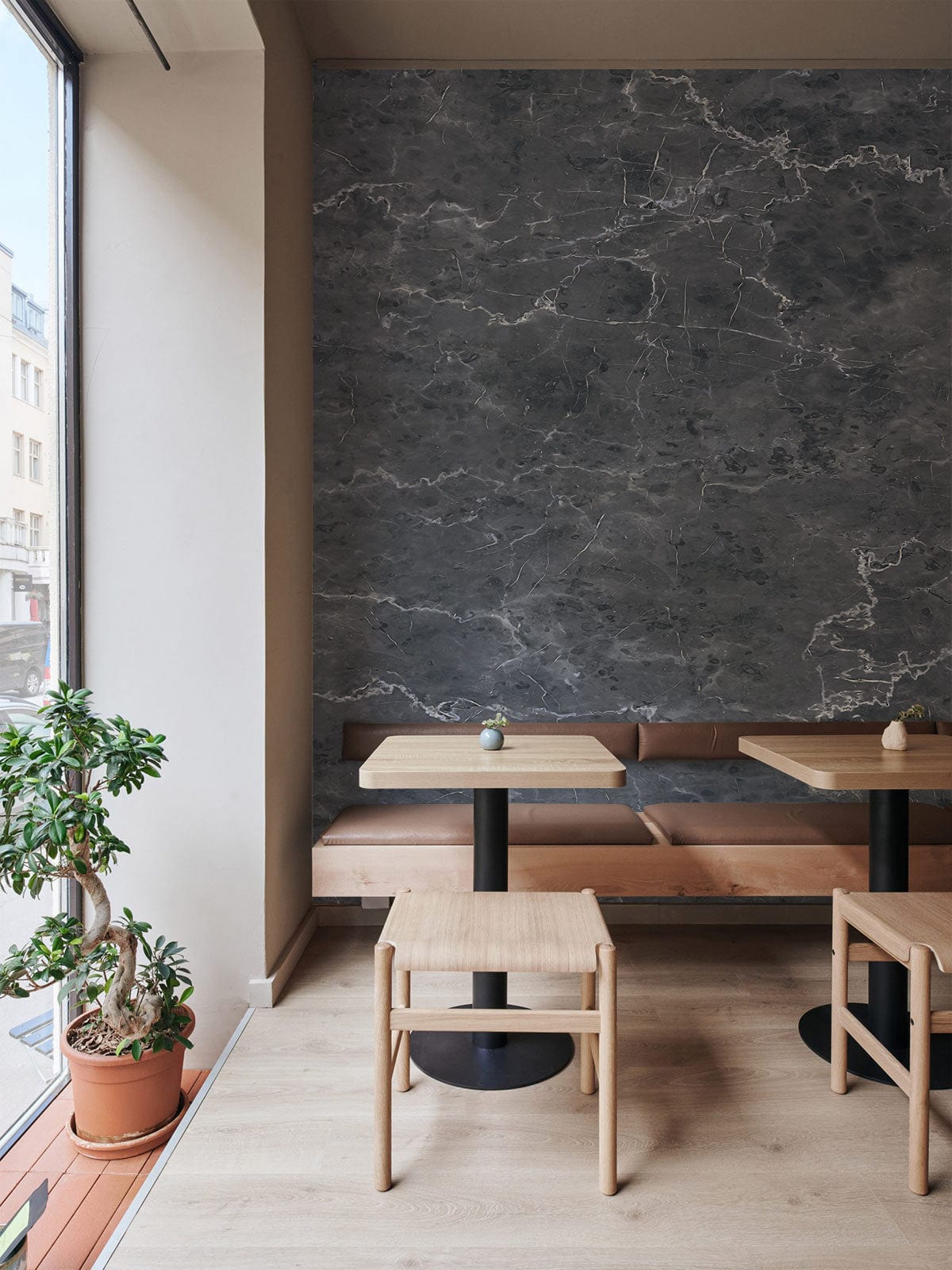 Luxurious Charcoal Marble Pattern Wallpaper in stylish cafe, featuring beige walls, wooden furniture, light flooring.
