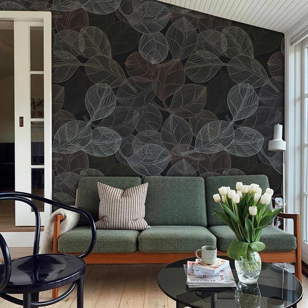 Elegant dark leaf pattern wallpaper with green sofa, light wooden flooring, black chair in living room.