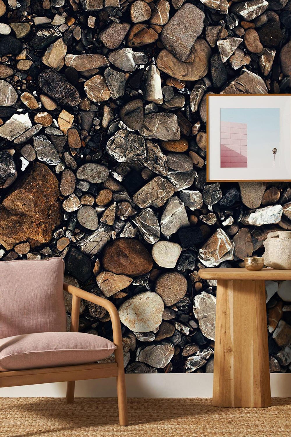 Natural stone pebble pattern wallpaper with earthy tones; wooden table and beige armchair included.