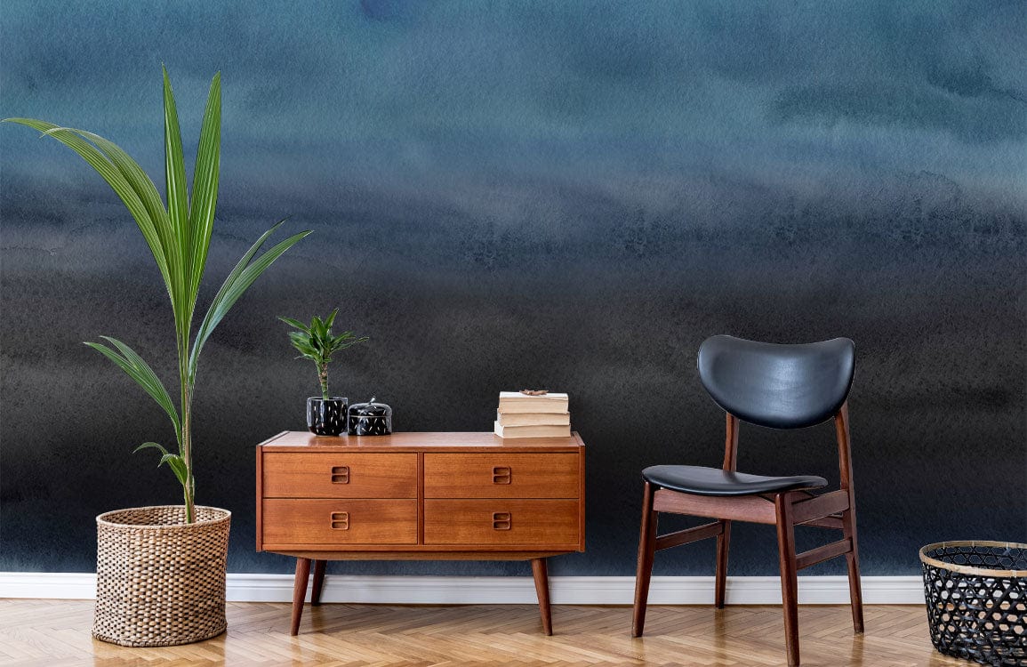 Moody Ocean Mist Watercolour mural wallpaper with mid-century sideboard, black chair, plant, wooden flooring.
