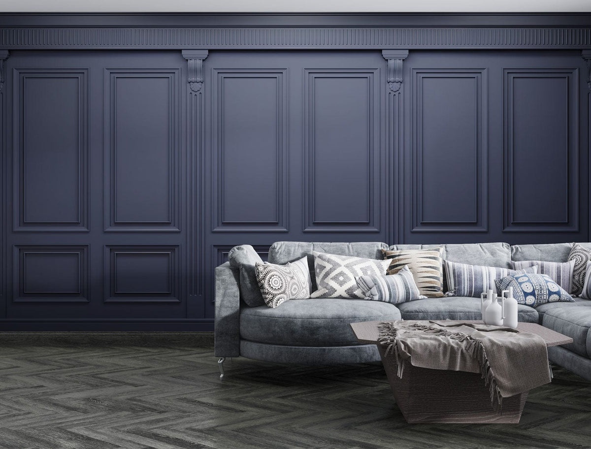 Elegant navy wallpaper with panelling, grey sectional sofa, geometric patterned floor, sophisticated living room.
