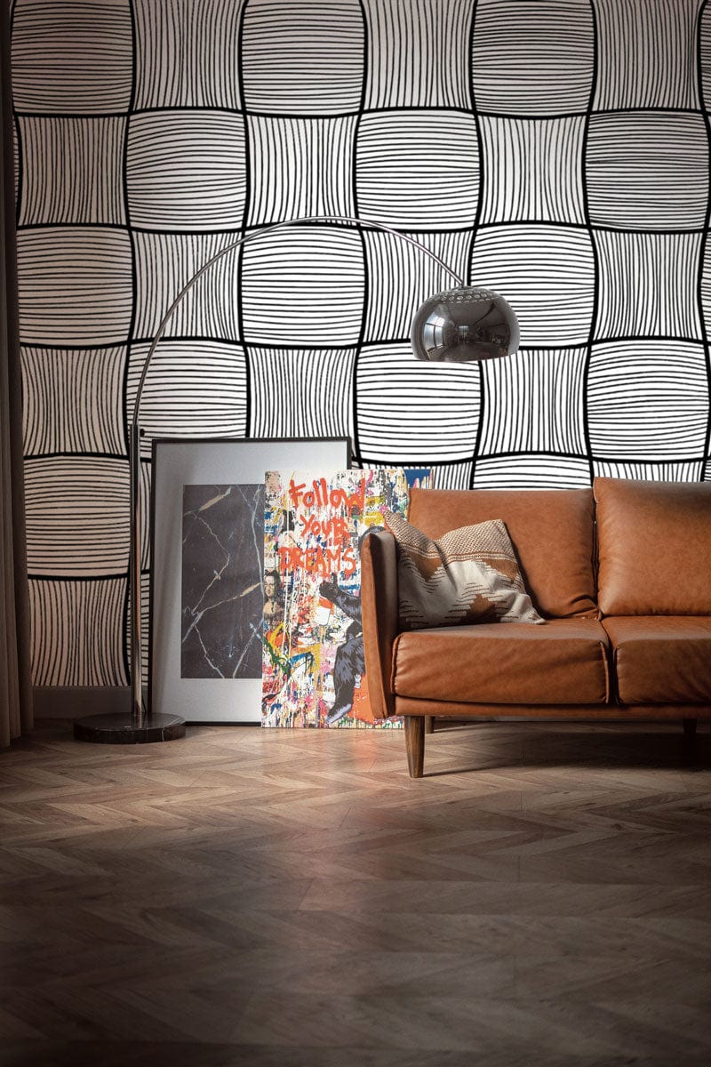 Monochrome geometric wallpaper, leather sofa, parquet flooring, artwork, modern interior decor, living room design.