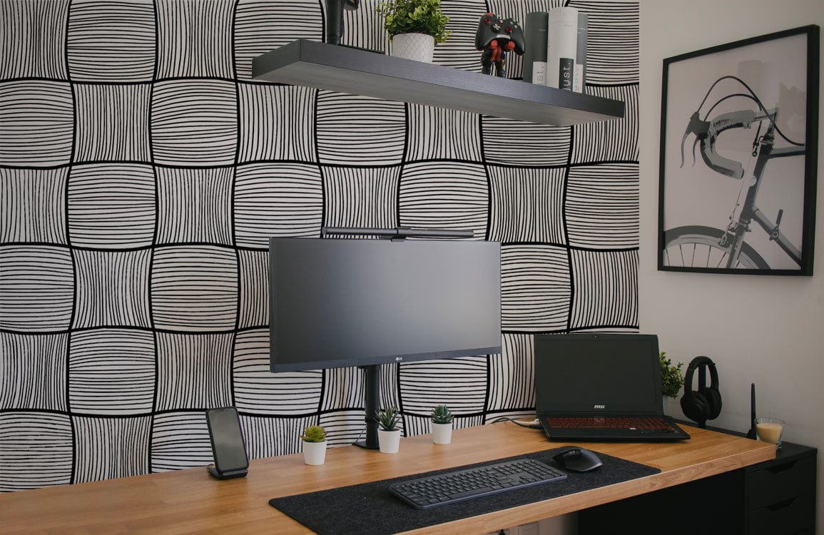 Monochrome geometric curved lines wallpaper in home office, black shelving, wooden desk, modern decor.
