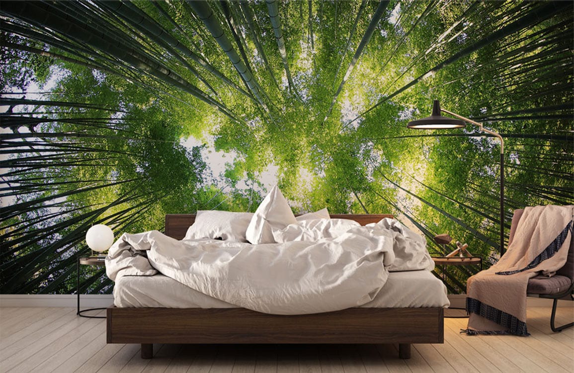Serene Green Forest Canopy Mural Wallpaper enhances bedroom with wooden bed, lamp, chair, light flooring.