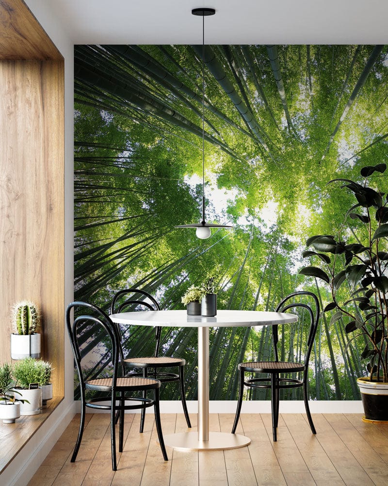Modern dining area with Serene Green Forest Canopy Mural Wallpaper, black chairs, and light wood flooring.