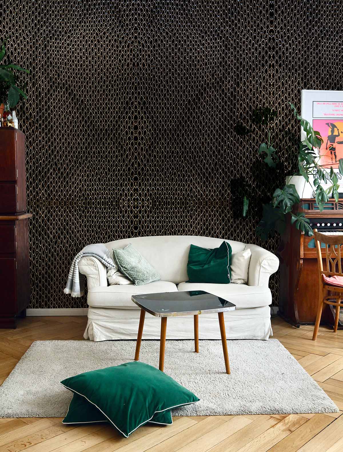 Luxurious textured brown geometric wallpaper with cream sofa, green cushions, wooden flooring in modern living room.