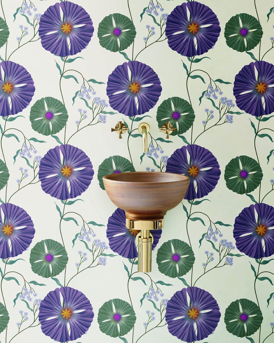 Vintage purple floral wallpaper with green accents, brass taps, and ceramic sink in elegant interior.