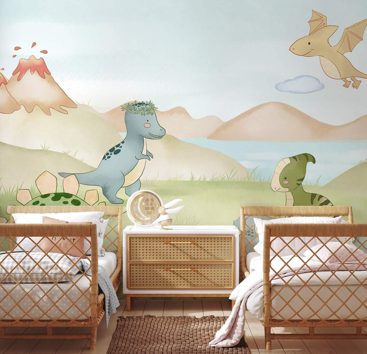 Charming pastel dinosaur mural wallpaper in a nursery with woven beds, rug, and light wooden flooring.