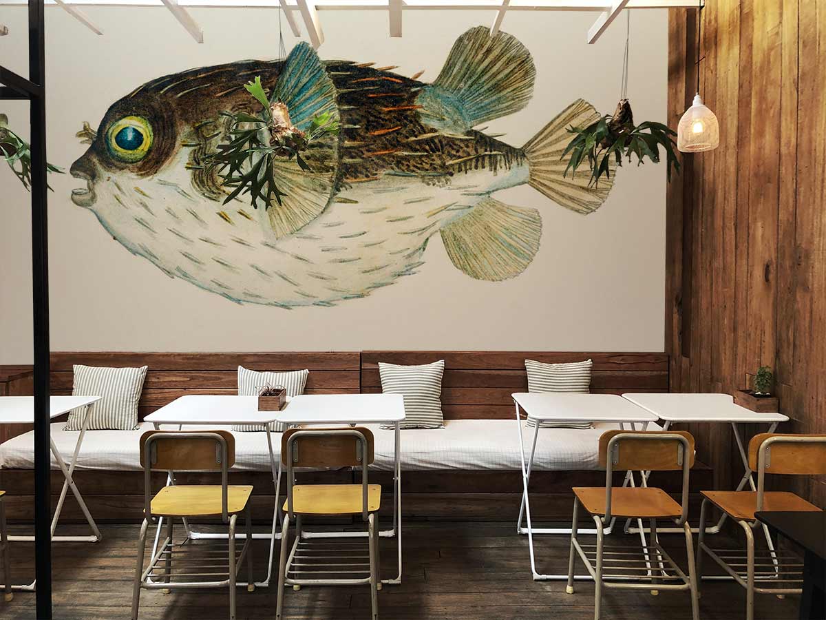 Vintage Nautical Pufferfish Wallpaper featuring soft blues and browns in rustic dining room with wooden accents.