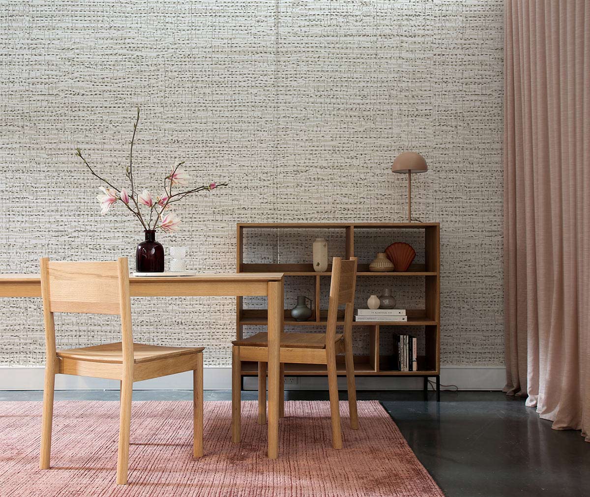 Textured beige wallpaper, neutral tone; modern dining room with wooden furniture, pink curtains, matching rug.