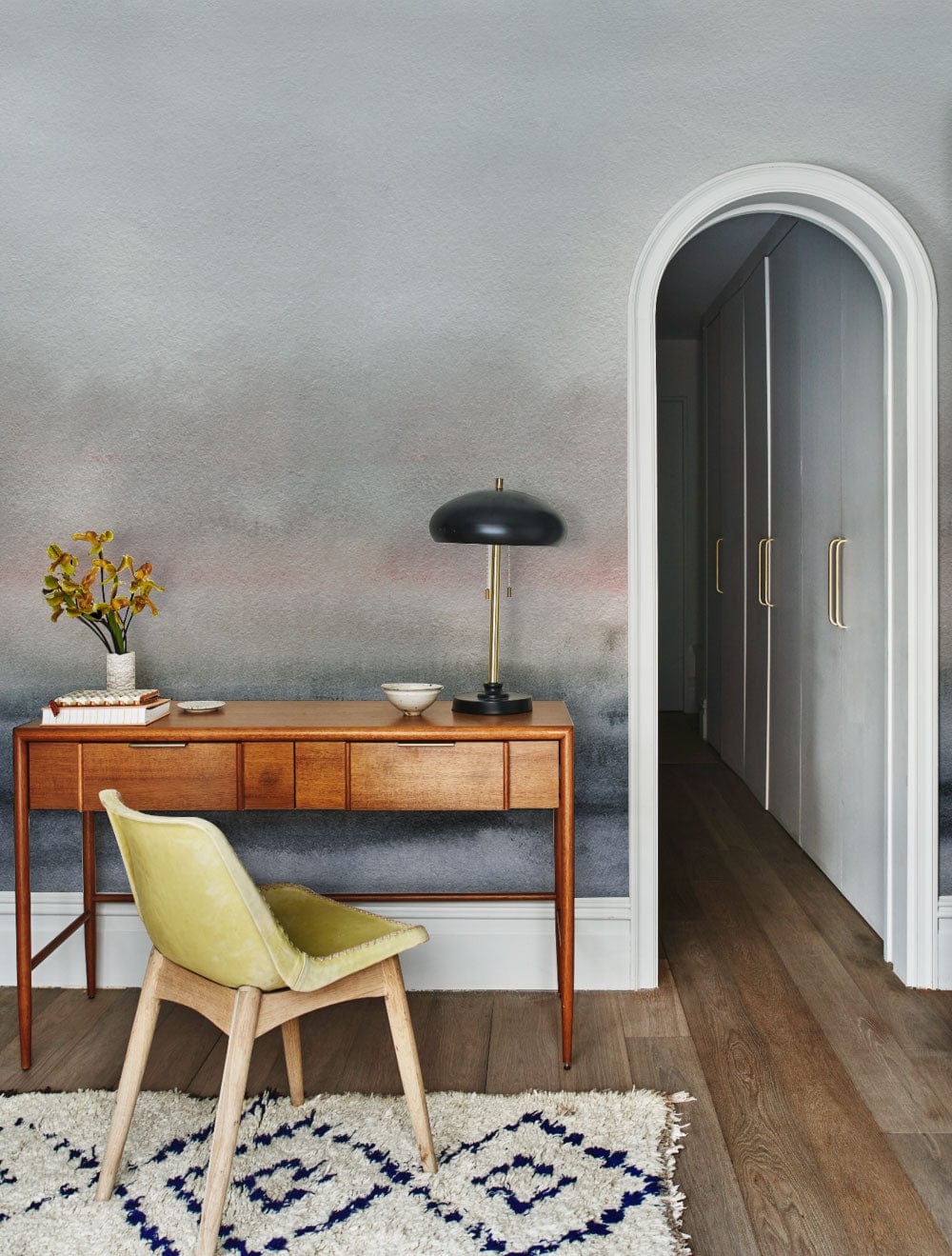 Serene Misty Landscape wallpaper in grey and pink with wooden desk, green chair, hardwood flooring.
