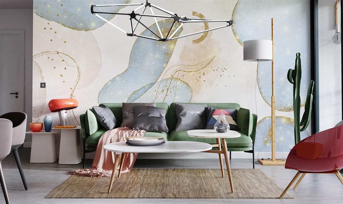 Dreamy blue and gold mural wallpaper in modern living room with green sofa and abstract decor.