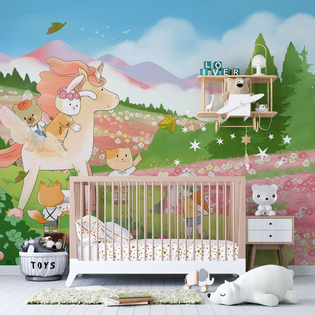 Nursery with whimsical animal mural wallpaper, wooden crib, white drawer, plush toys, and light wood floor.