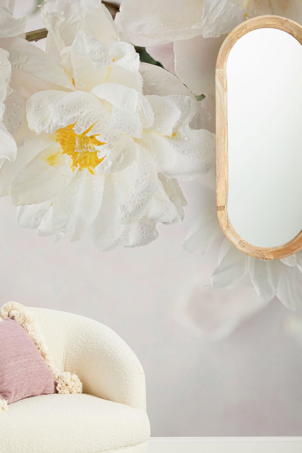 Elegant white floral mural wallpaper with a soft pastel background, curved armchair, and wood-framed mirror.