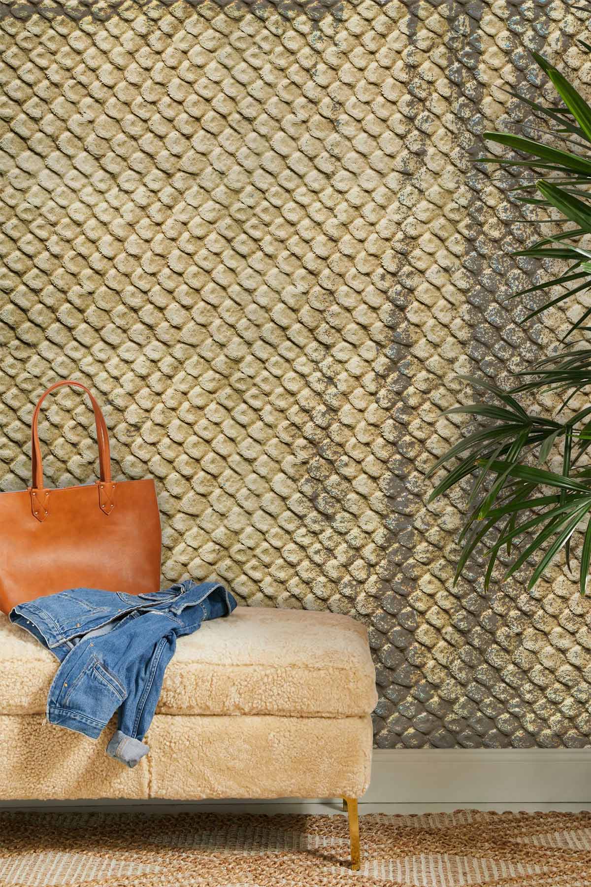 Rustic gold stone texture wallpaper in elegant living room with beige ottoman and green plant.