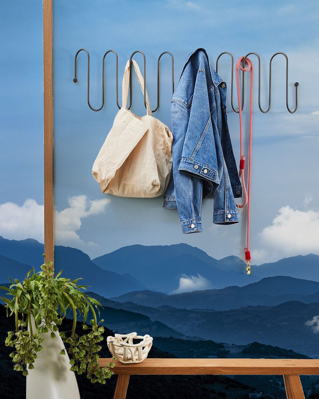 Majestic Blue Mountain Vista Mural Wallpaper in cosy room with wooden bench and wall hooks.
