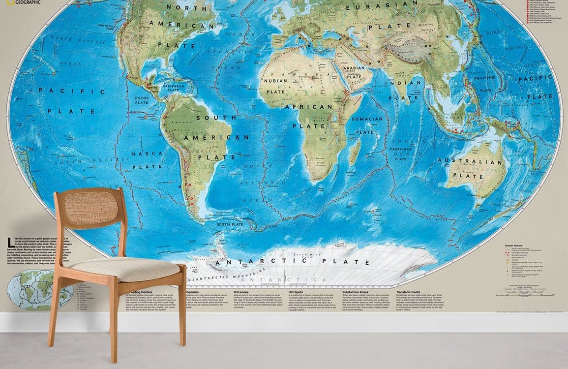 Vintage World Map Mural Wallpaper in blue and cream tones with wooden chair, grey flooring.