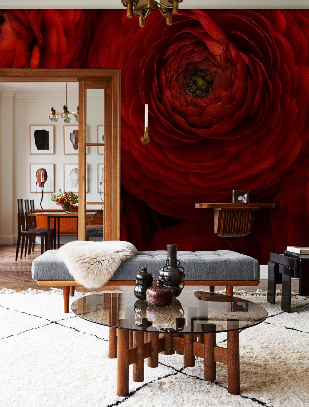 Luxurious red floral mural wallpaper, vibrant colours, grey sofa, glass table, cosy living room decor.