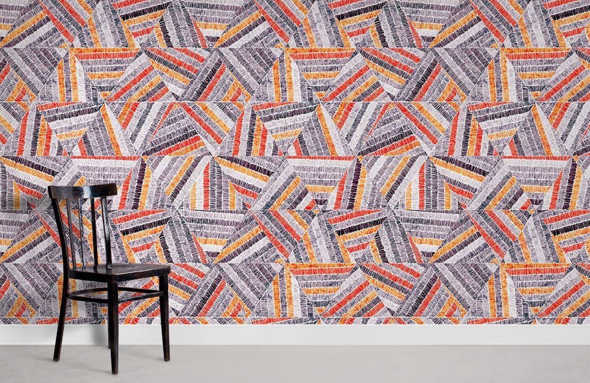 Vibrant geometric wallpaper in orange and grey with black chair, modern room, light flooring.