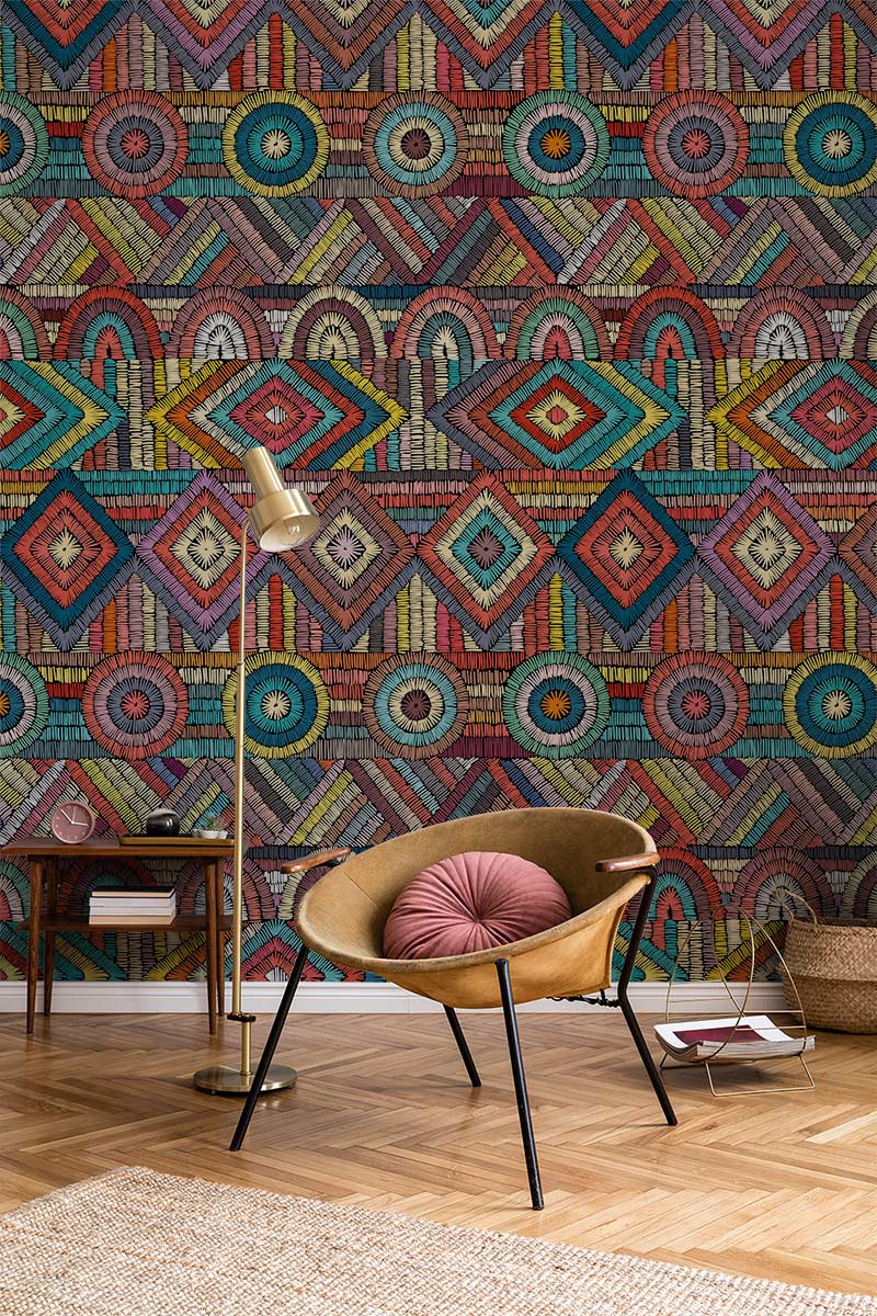 Vibrant geometric mosaic wallpaper with tribal Décor, featuring modern chair, wooden floor, and lamp.