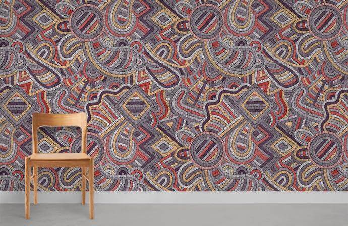 Alt text: Multicoloured geometric mosaic wallpaper, vibrant tribal design, wooden chair, grey floor, room setting.